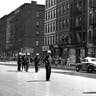 New York police officers wearing steel helmets and carrying nightsticks as they patrolled a street in the Harlem neighborhood of New York to prevent further rioting, Aug. 2, 1943. 