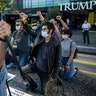 Demonstrators kneeling and raising their fists, during a protest against police brutality, outside the Trump Towers in Istanbul.