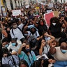 People making clenched-fist gestures during a protest against racism and police violence in Lisbon, Portugal.