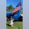 Almost 2 year old Mackenzie May wade saluting our flag on flag day at happy day farms at the start of raspberry picking season