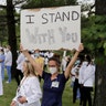 Health care professionals outside Barnes-Jewish Hospital demonstrate in support of the Black Lives Matter movement, June 5, 2020, in St. Louis, Mo.