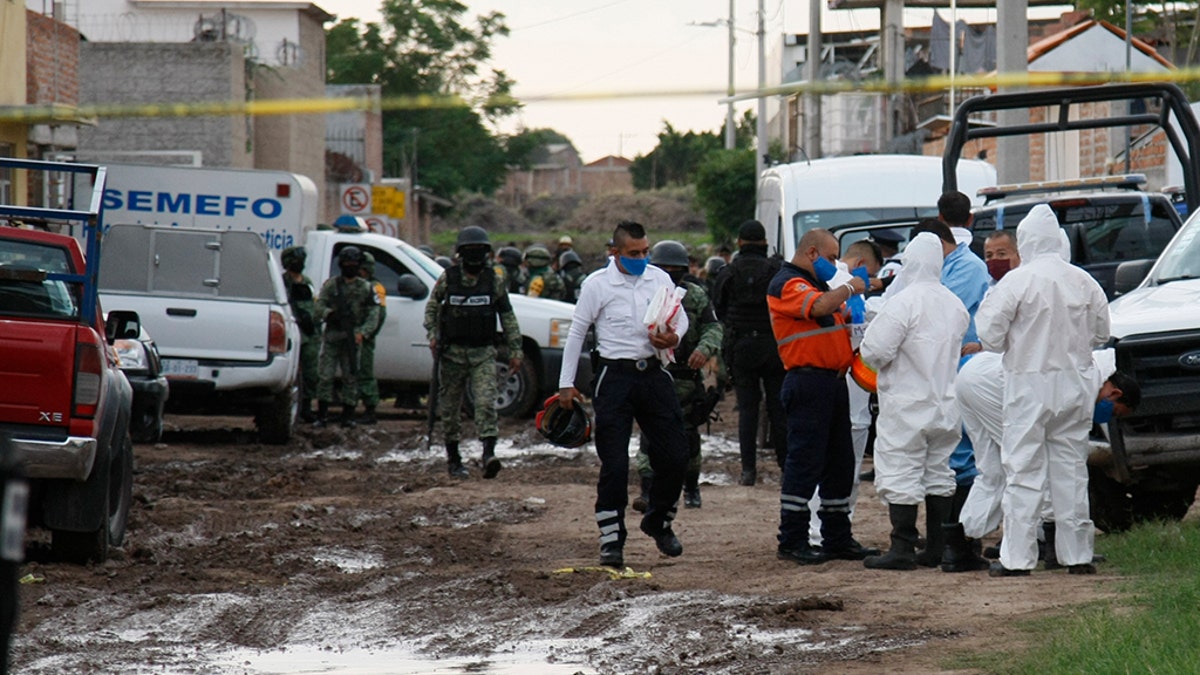 Forensic service personnel prepare to enter an unregistered drug rehabilitation center in Irapuato, Mexico, Wednesday, July 1, 2020. (Associated Press)