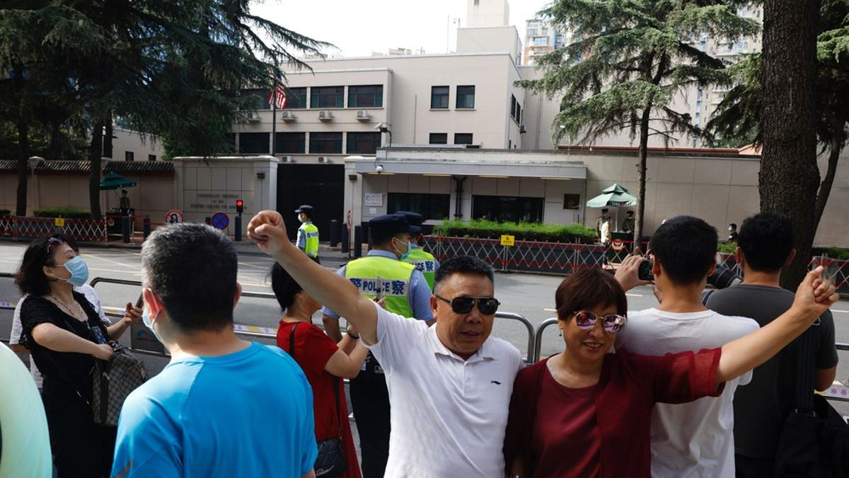Residents raise their fists to pose for a photo outside the United States Consulate in Chengdu in southwest China's Sichuan province on Sunday, July 26, 2020. China ordered the United States on Friday to close its consulate in the western city of Chengdu, ratcheting up a diplomatic conflict at a time when relations have sunk to their lowest level in decades.
