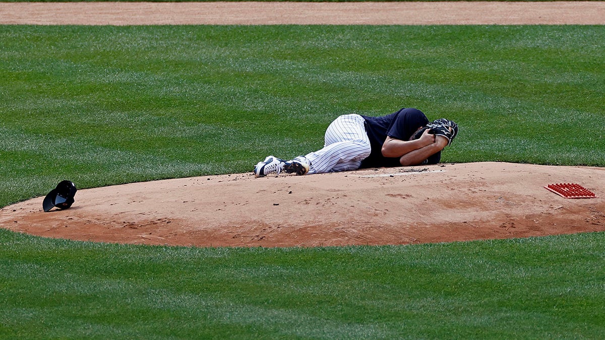 New York Yankees pitcher Masahiro Tanaka lies on the field after being hit by a ball off the bat of Yankees Giancarlo Stanton during a baseball a workout at Yankee Stadium in New York, Saturday, July 4, 2020. (Associated Press)