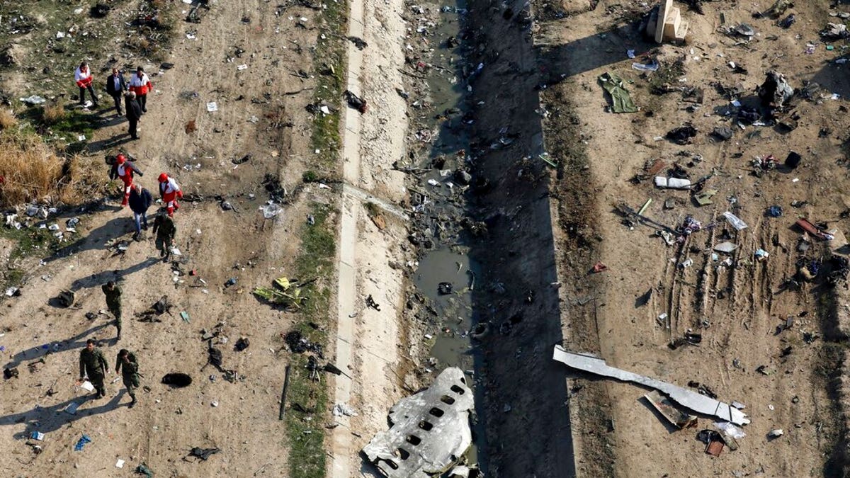 FILE: Rescue workers search the scene where a Ukrainian plane crashed in Shahedshahr, southwest of Tehran, Iran. 