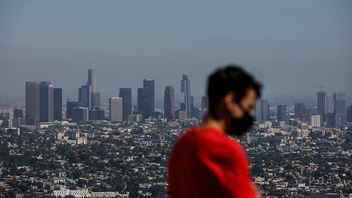 Izzy Galvan, 20, wears a face mask while visiting the Griffith Observatory overlooking downtown Los Angeles, Wednesday, July 15, 2020, in Los Angeles. (AP Photo/Jae C. Hong)