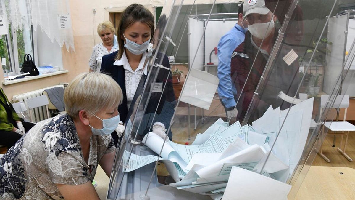 Members of an election commission, wearing face masks and gloves to protect against coronavirus, prepare to count ballots after voting at a polling station in eastern Siberian city of Chita, Russia, July 1, 2020. 