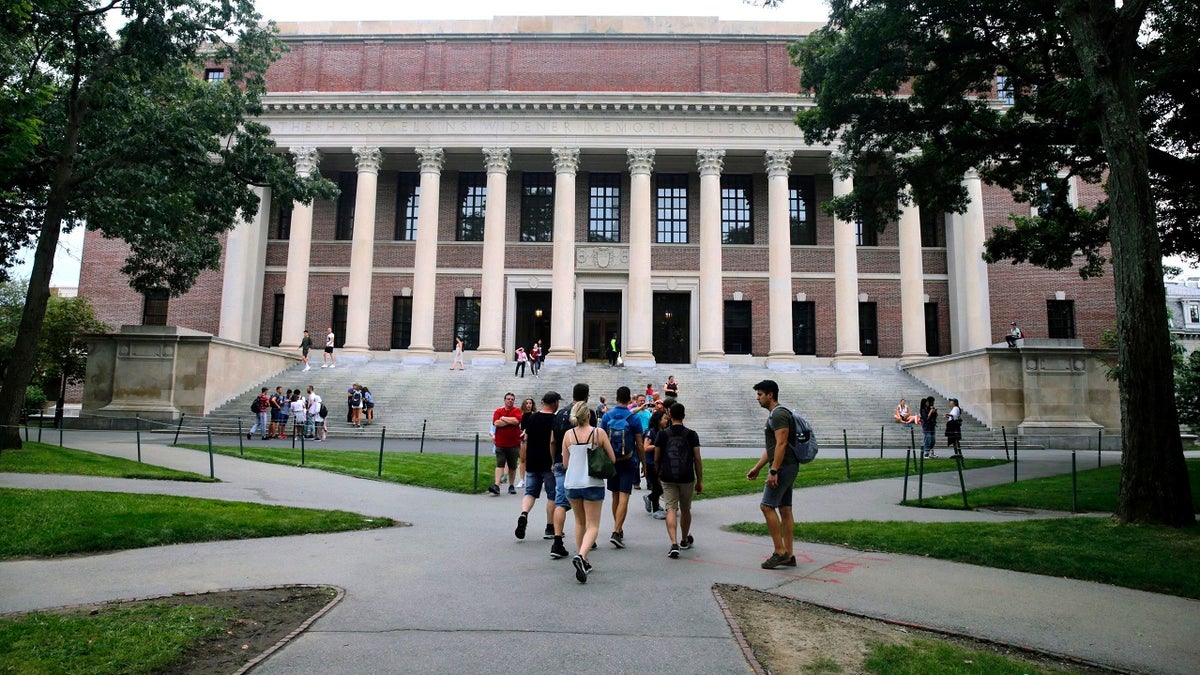 In this Aug. 13, 2019 file photo, students walk near the Widener Library in Harvard Yard at Harvard University in Cambridge, Mass. The Ivy League school announced Monday that as the coronavirus pandemic continues its freshman class will be invited to live on campus this fall, while most other undergraduates will be required to learn remotely from home. (AP Photo/Charles Krupa, File)