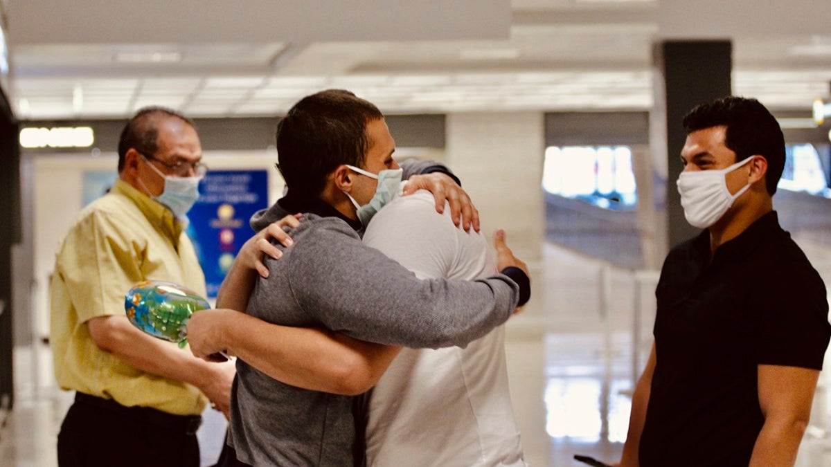 In this image provided by the Freedom Initiative Mohamed Amashah, second from left, is greeted by family members upon arrival at Dulles International Airport in Dulles, Va., on Monday. The American medical student detained without trial in an Egyptian prison for nearly 500 days has been freed and returned to the United States, the U.S. State Department said on Monday. (Bushra Soltan/Freedom Initiative via AP)