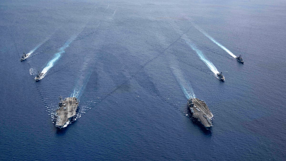 Two US aircraft carriers sail through the South China Sea. China has simulated attacks on US warships.