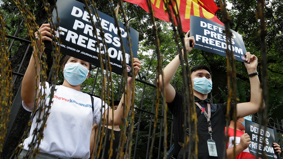 Supporters of the country's largest TV network, ABS-CBN, holds slogans during a rally outside the House of Representatives in Manila, Philippines, Thursday, July 9, 2020. (Associated Press)