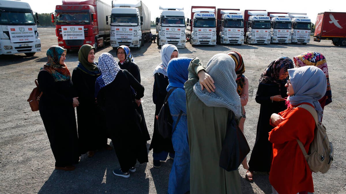 FILE - In this Sept. 10, 2018 file photo, members of a Turkish pro-government aid group, wait for the departure of trucks carrying humanitarian aid destined for Idlib, Syria, in Istanbul. (AP Photo/Lefteris Pitarakis, File)