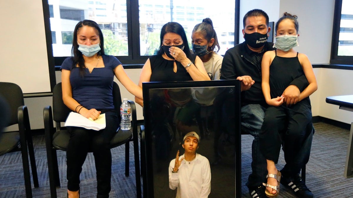 Lucy Carbajal, center left, sits behind a photograph of her son Bernardo Palacios-Carbajal while other family members look on during a press conference at their attorney's office on Thursday in Salt Lake City. (AP Photo/Rick Bowmer)