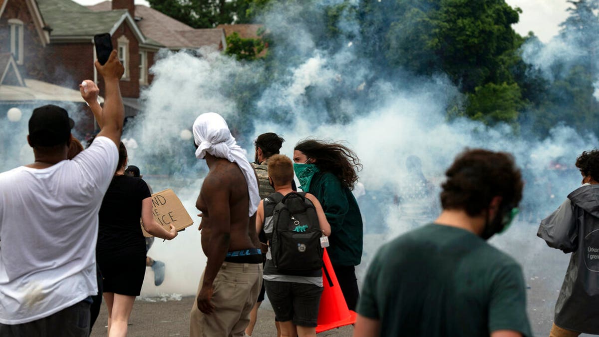 Protesters against police brutality clash with police during a march near where 20-year-old Hakeem Littleton was killed in a shootout with Detroit police earlier in the day, Friday July 10, 2020, in Detroit. (Nicole Hester/Ann Arbor News via AP)