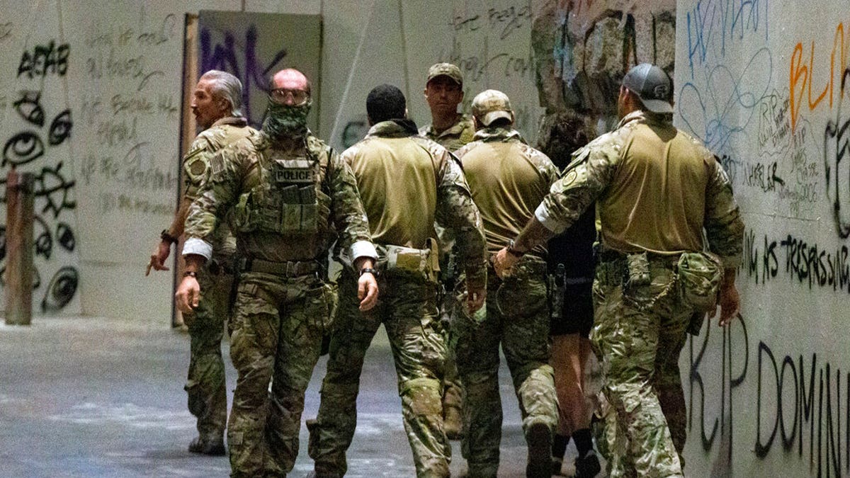 In this Friday, July 10, 2020, file photo, federal officers pull a protester into the Federal Courthouse as protesters gather in downtown Portland, Ore.
