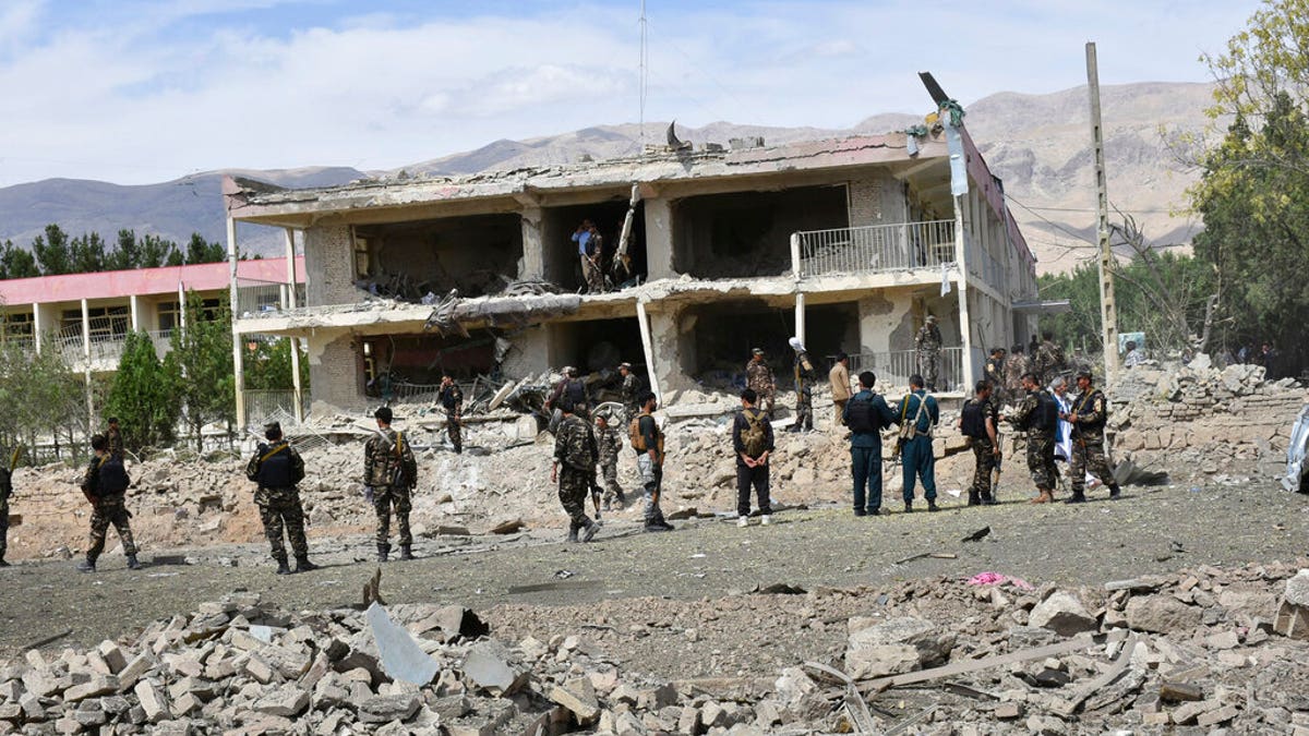Afghan security personnel inspect the site of a car bomb blast on an intelligence compound in Aybak, the capital of the Samangan province in northern Afghanistan, July 13. Taliban insurgents launched a complex attack on the compound that began with a suicide bombing, officials said. (AP Photo)