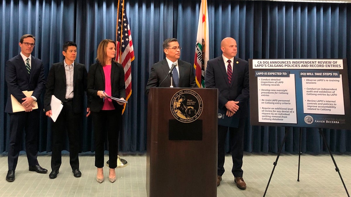 California Attorney General Xavier Becerra, second from right, revoked access to entries Los Angeles police made in the state's gang database after three officers were charged with falsifying records, authorities said Tuesday, July 14, 2020. (AP Photo/Stefanie Dazio, File)