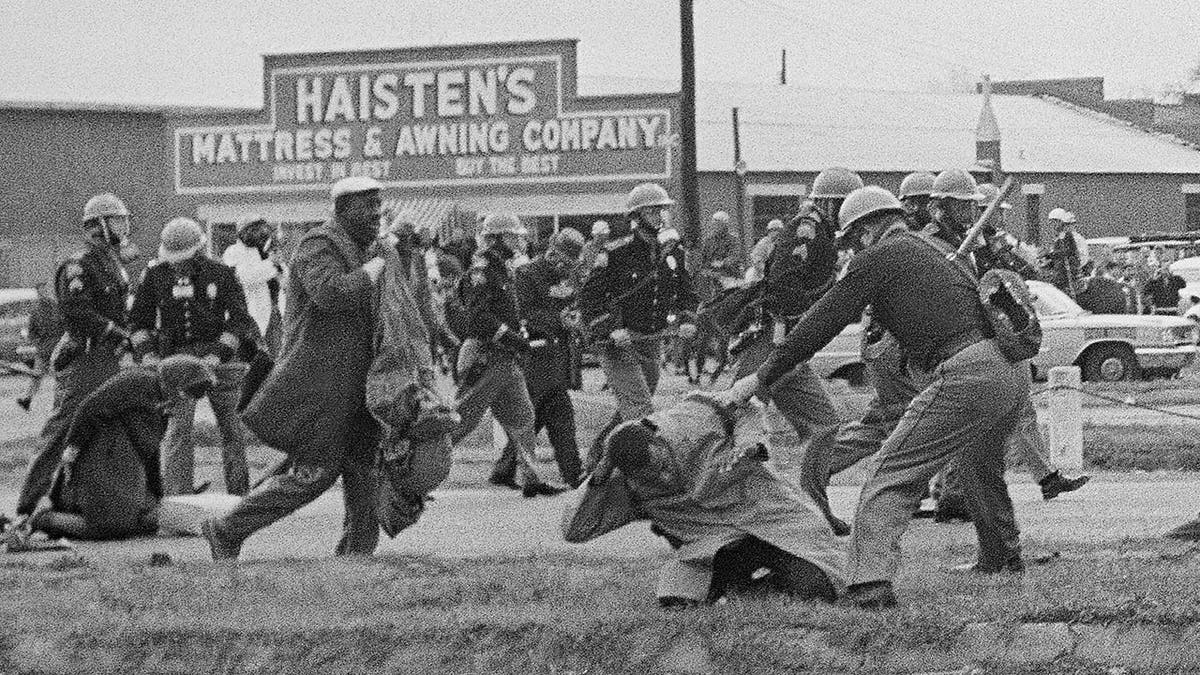 In this March 7, 1965, file photo, a state trooper swings a billy club at John Lewis, right foreground, chairman of the Student Nonviolent Coordinating Committee, to break up a civil rights voting march in Selma, Ala. Lewis sustained a fractured skull. Lewis, who carried the struggle against racial discrimination from Southern battlegrounds of the 1960s to the halls of Congress, died Friday, July 17, 2020.