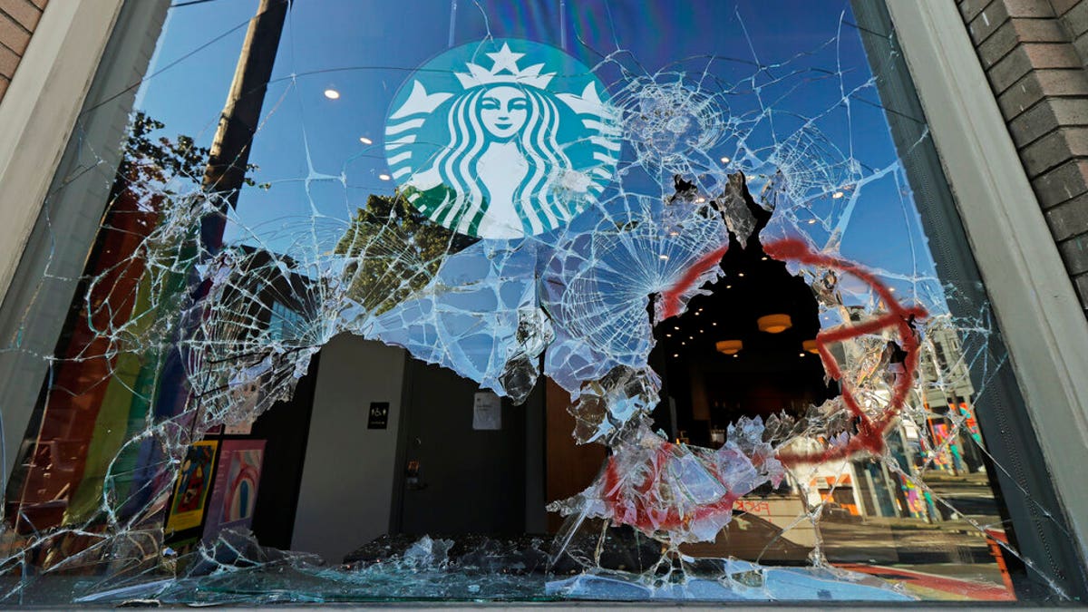 Broken windows are shown at a Starbucks store, Sunday, July 19, 2020 in Seattle's Capitol Hill neighborhood. Protesters broke windows at the store earlier in the afternoon. (AP Photo/Ted S. Warren)