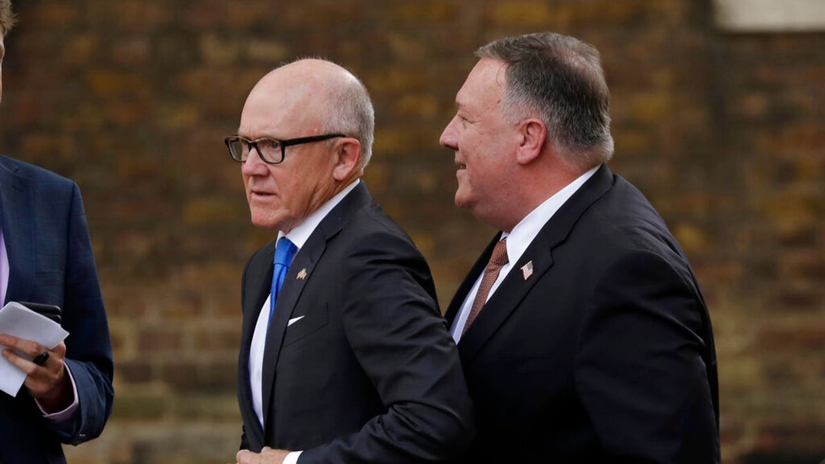 U.S. Secretary of State Mike Pompeo, right, passes Woody Johnson the U.S. Ambassador to Britain as he walks to 10 Downing Street in London, for his meeting with British Prime Minister Boris Johnson, Tuesday, July 21, 2020. (AP Photo/Matt Dunham)