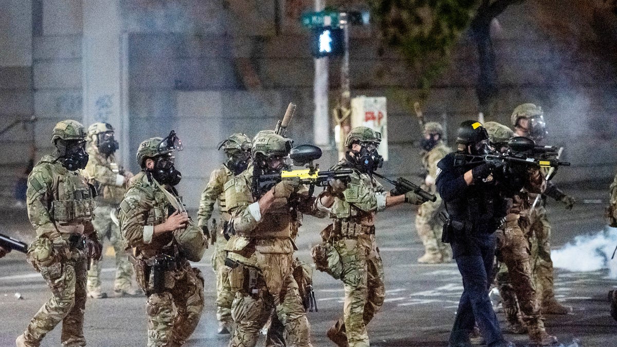 Federal agents use crowd control munitions to disperse Black Lives Matter protesters at the Mark O. Hatfield United States Courthouse in Portland, Ore. on July 20, 2020. Officers used teargas and projectiles to move the crowd after some protesters tore down a fence fronting the courthouse. (AP Photo/Noah Berger)