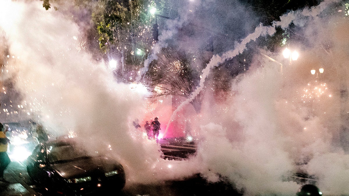Smoke fills the sky as federal officers try to disperse Black Lives Matter demonstrators on Wednesday, July 22, 2020, in Portland, Ore. (AP Photo/Noah Berger)