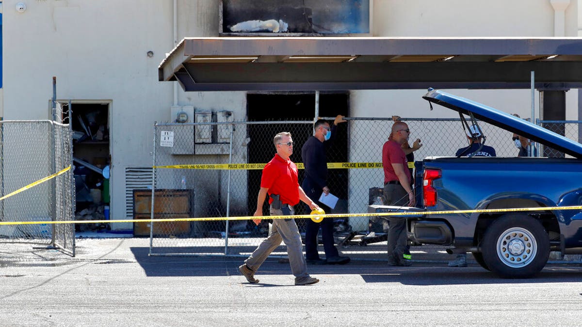 Fire investigators stand outside the Arizona Democratic Party headquarters Friday, July 24, 2020, in Phoenix. (Associated Press)