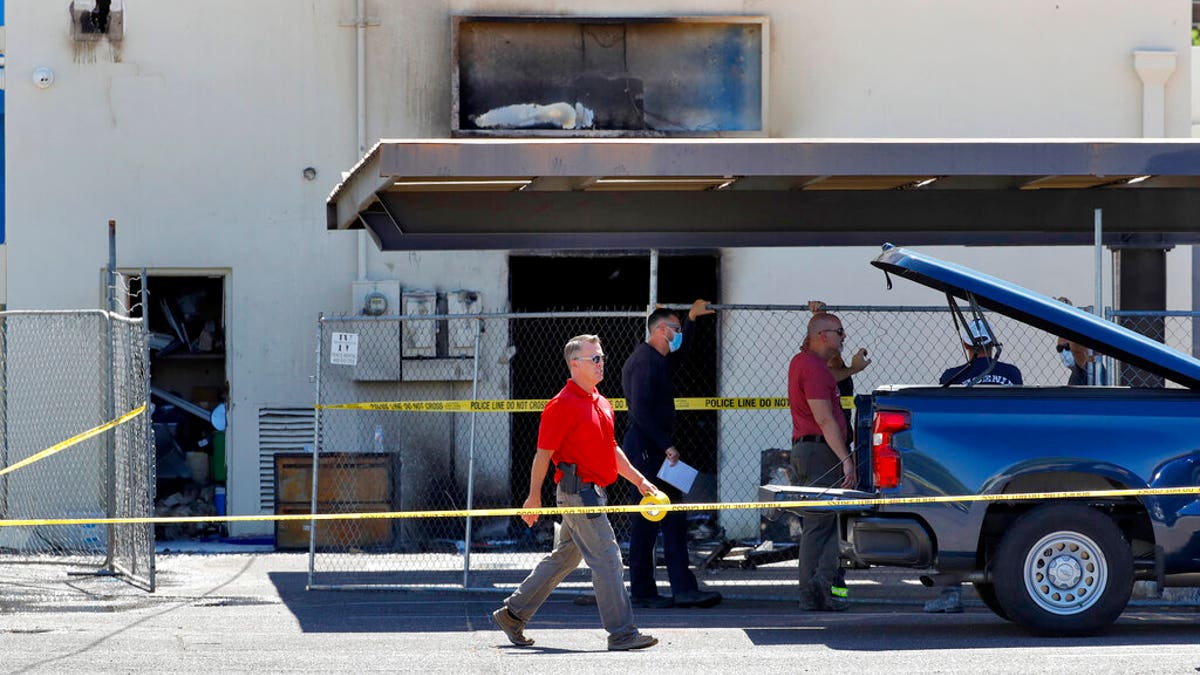 Fire investigators stand outside the Arizona Democratic Party headquarters Friday, July 24, 2020, in Phoenix. (Associated Press)