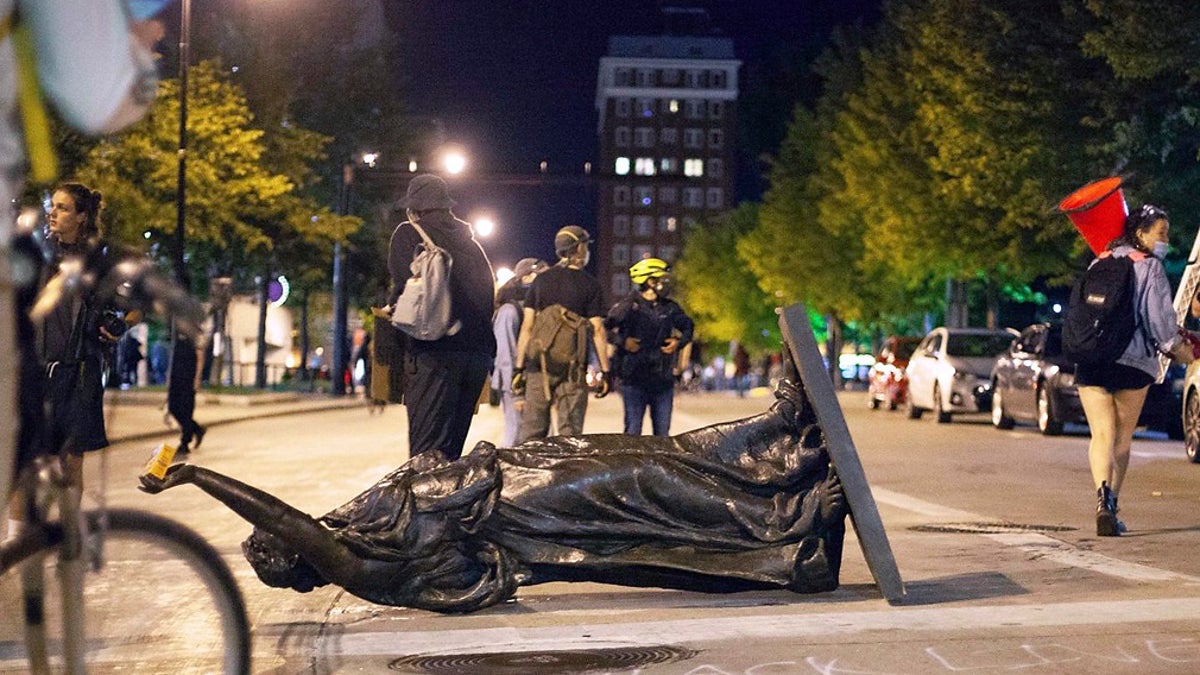 In this June 23, 2020 file photo, Wisconsin's "Forward" statue lies in the street on Capitol Square in Madison, Wis. Crowds outside the Wisconsin State Capitol tore down two statues and attacked a state senator amid protests following the arrest of a Black man who shouted at restaurant customers through a megaphone while carrying a baseball bat. (Emily Hamer/Wisconsin State Journal via AP, File)