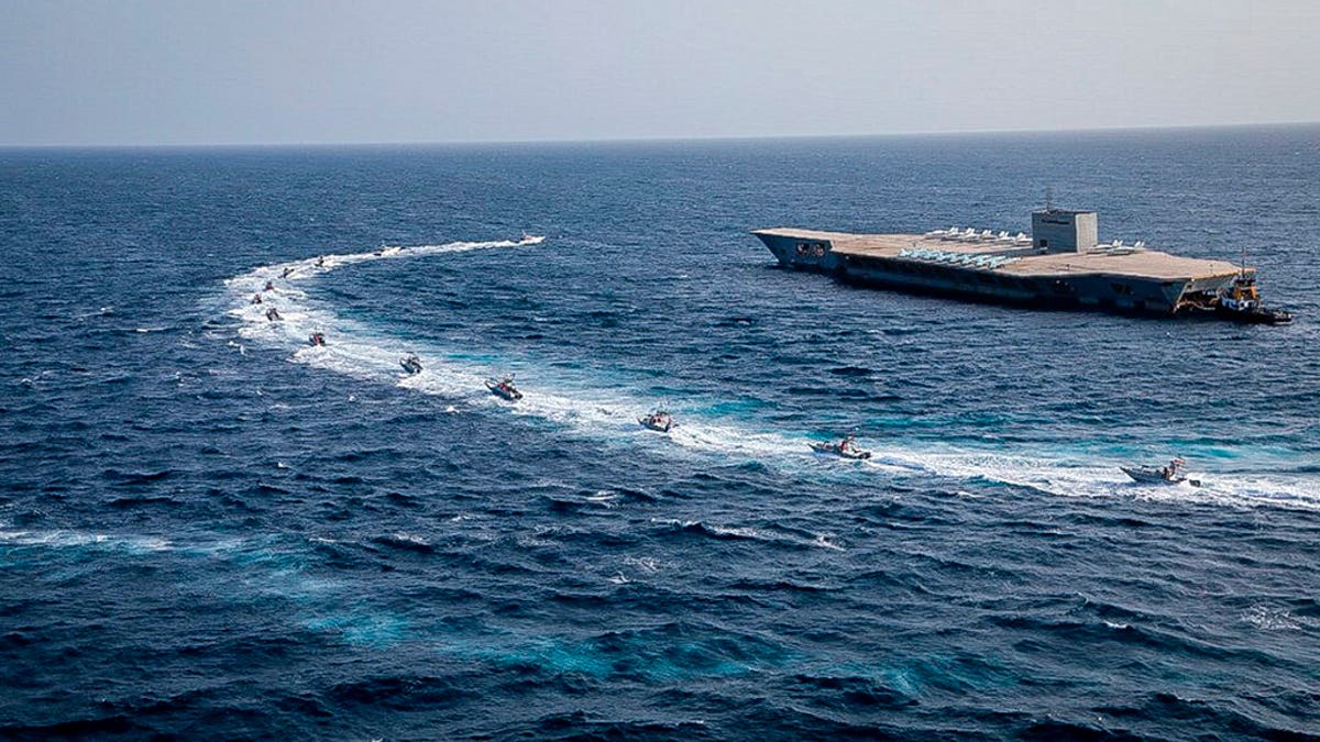 Revolutionary Guard's speed boats circle around a replica American aircraft carrier during a military exercise. (Sepahnews via AP)