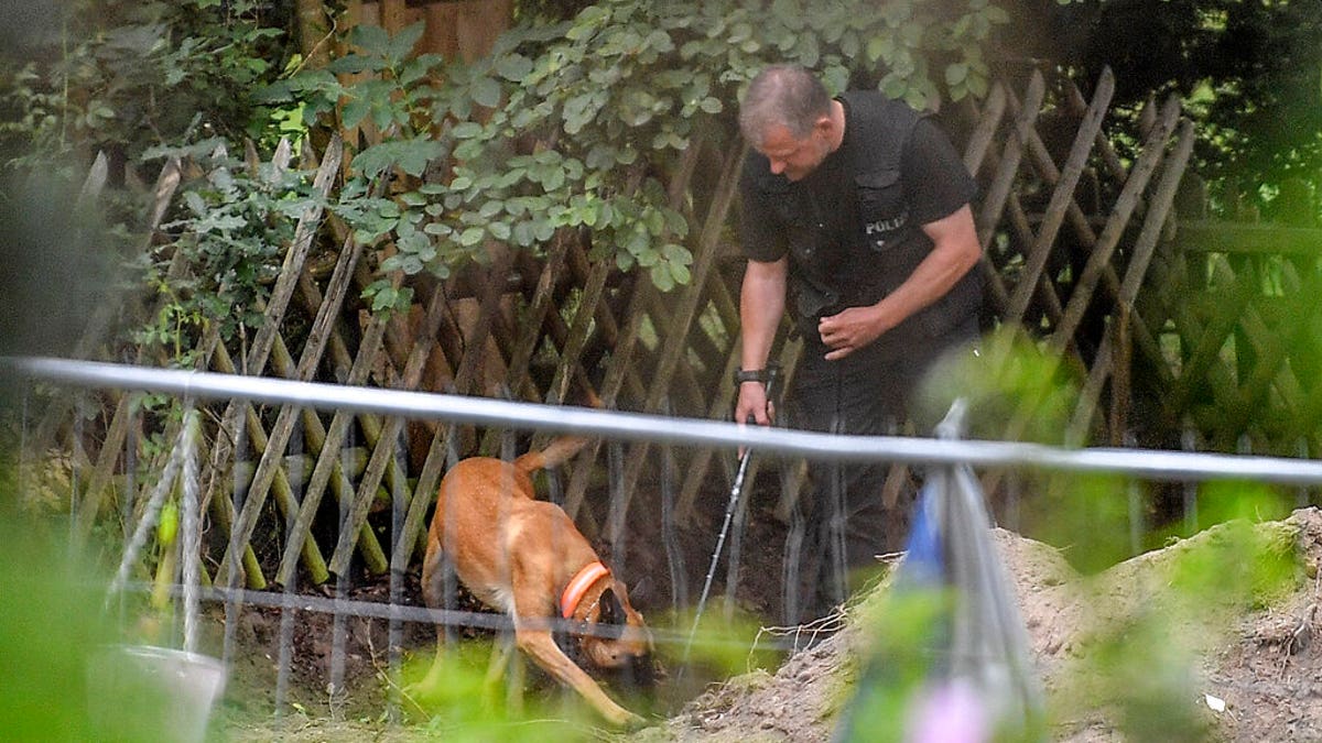 Germany police officers search with dogs an allotment garden plot in Seelze, near Hannover, Germany, Wednesday, July 29, 2020. (AP Photo/Martin Meissner)