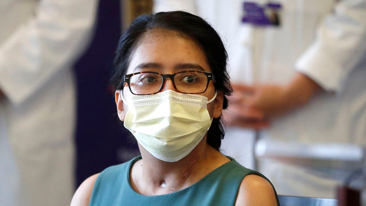 Mayra Ramirez, a COVID-19 survivor due to a double-lung transplant, listens Thursday, July 30, 2020, to a question about her journey through the pandemic during her first news conference at Northwestern Memorial Hospital in Chicago. Ramirez is the first known patient in the United States who received double-lung transplants due to COVID-19. (AP Photo/Charles Rex Arbogast)