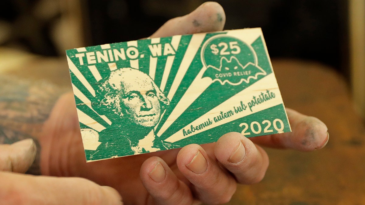 In an effort to help residents and local merchants alike get through the economic fallout of the coronavirus pandemic, the small town has issued wooden currency for residents to spend at local businesses, decades after it created a similar program during the Great Depression. (AP Photo/Ted S. Warren)