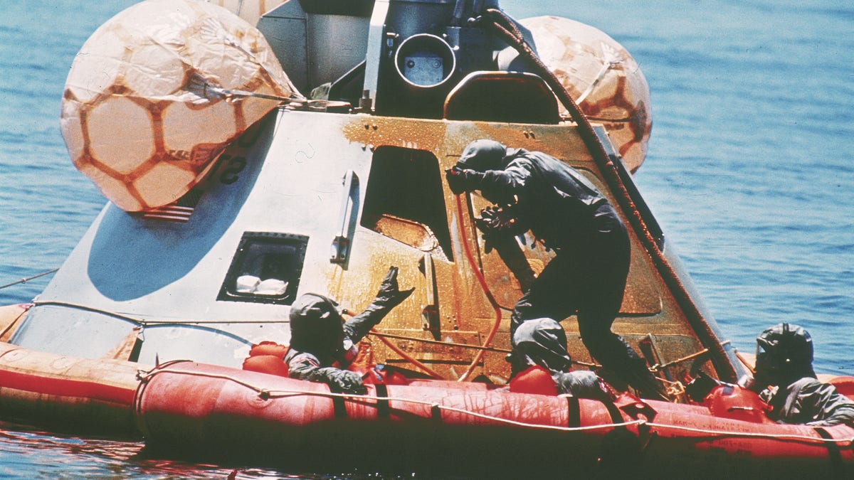 U.S. Navy personnel, protected by Biological Isolation Garments, are recovering the Apollo 11 crew from a re-entry vrehicle, which landed safely in the Pacific Ocean on July 24, 1969, after an eight-day mission on the moon. (AP Photo)