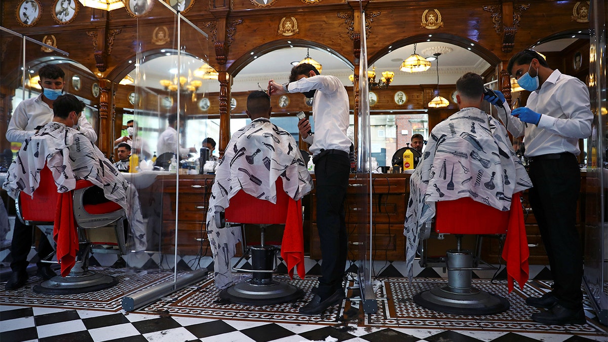 Men have their hair cut at Savvas Barbers as it reopened following the outbreak of the coronavirus disease (COVID-19), in London, Britain July 4, 2020. REUTERS/Hannah McKay - RC29MH9YHVPQ