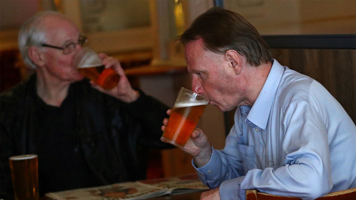 Customers drink beer at The Holland Tringham Wetherspoons pub after it reopened following the outbreak of the coronavirus disease (COVID-19), in London, Britain July 4, 2020. REUTERS/Hannah McKay - RC2AMH9ARMHE