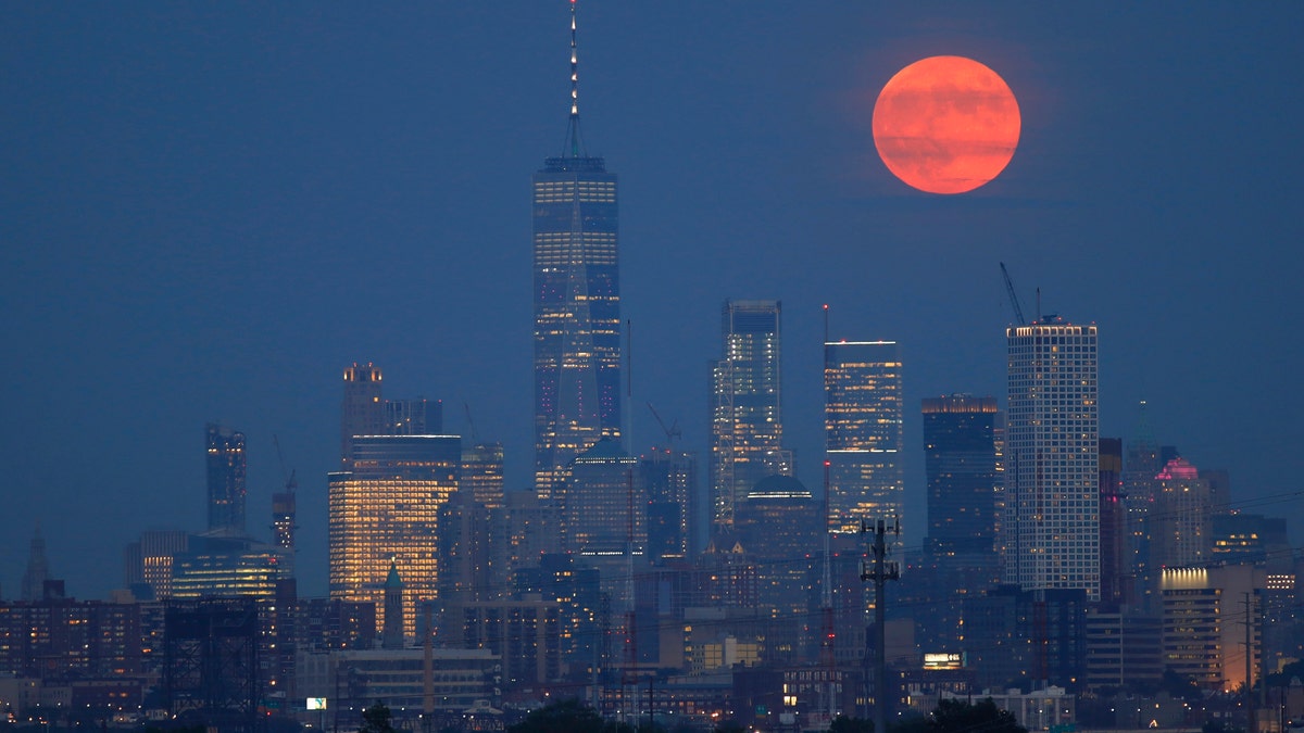 On the 50th anniversary of the launch of Apollo 11, the full buck moon rises above the skyline of lower Manhattan and One World Trade Center in New York City on July 16, 2019 as seen from Kearney, New Jersey - file photo.