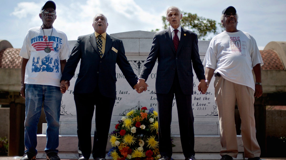 FILE - In this April 4, 2012  photo, civil rights activists and Southern Christian Leadership Conference members, from left, Ralph Worrell, Dr. Bernard Lafayette, Jr., C.T. Vivian and Frederick Moore, join hands and sing "We Shall Overcome" at the Atlanta gravesite of Rev. Martin Luther King Jr., marking the 44th anniversary of his assassination. The Rev. Vivian, a civil rights veteran who worked alongside the Rev. Martin Luther King Jr. and served as head of the organization co-founded by the civil rights icon, has died at home in Atlanta of natural causes July 17, his friend and business partner Don Rivers confirmed to The Associated Press. Vivian was 95. (AP Photo/David Goldman, File)