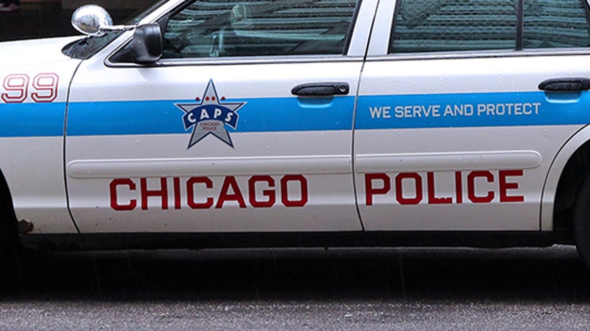 Chicago, United States - June 26, 2013: People walk past police car on June 26, 2013 in Chicago. Chicago Police Department is one of oldest police forces in the world, dating back to 1837.