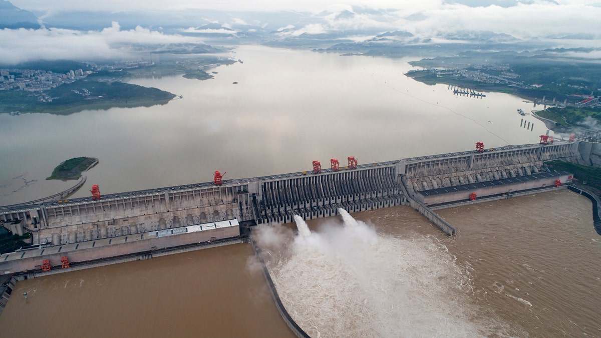 In this photo released by China's Xinhua News Agency, water flows out from sluiceways at the Three Gorges Dam on the Yangtze River near Yichang in central China's Hubei Province, Friday, July 17, 2020. 