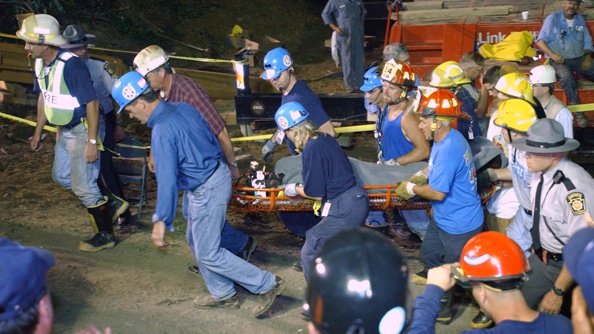 Pennsylvania Gov. Mark Schweiker, left, helps carry out the last of the trapped miners at the Quecreek Mine in Somerset, Pa., Sunday July 28, 2002. (AP Photo/Steve Helber/POOL)