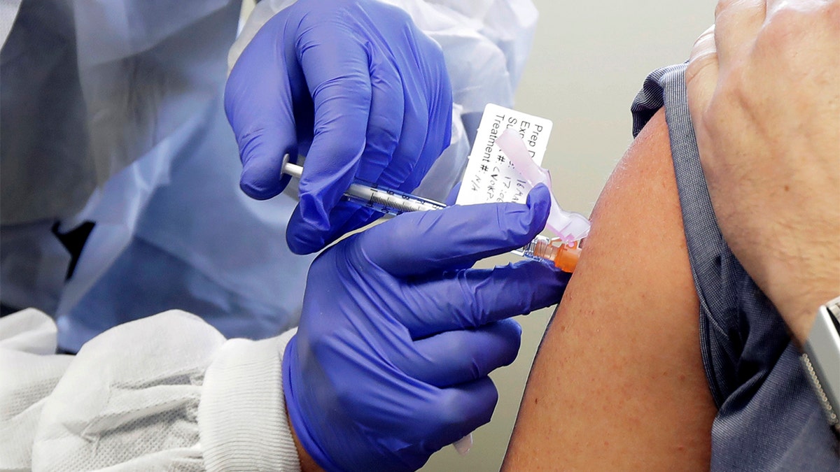 In this March 16, 2020, file photo, a subject receives a shot in the first-stage safety study clinical trial of a potential vaccine by Moderna for COVID-19, the disease caused by the new coronavirus, at the Kaiser Permanente Washington Health Research Institute in Seattle. According to results released on Tuesday, July 14, 2020, early-stage testing showed the first COVID-19 vaccine tested in the U.S. revved up people’s immune systems the way scientists had hoped. The vaccine is made by the National Institutes of Health and Moderna Inc. (AP Photo/Ted S. Warren, File)
