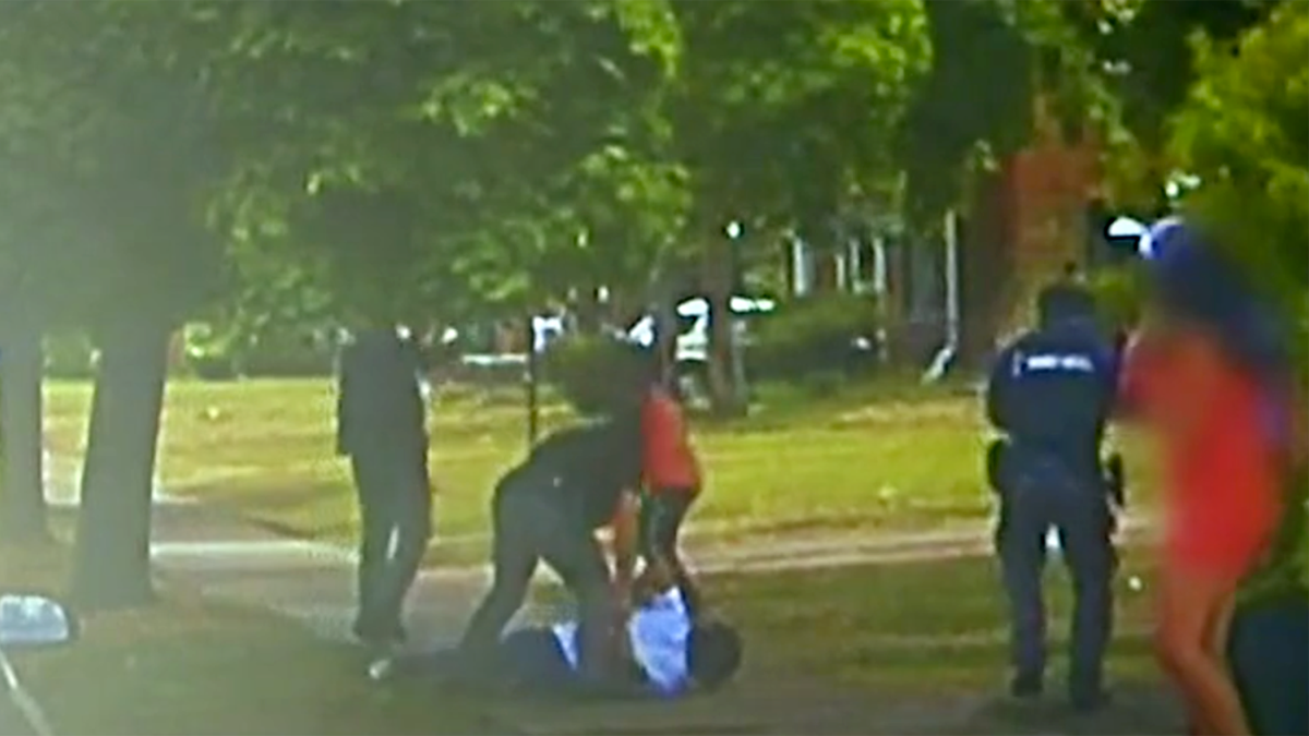 Police footage show officers arresting Darnell Sylvester moments before his friend, Hakeem Littleton (in orange shirt) opens fire on officers.