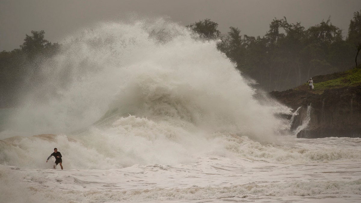 A surfer takes on a wave generated by Hurricane Douglas at Laie Beach Park, Sunday, July 26, 2020, in Laie, Hawaii.