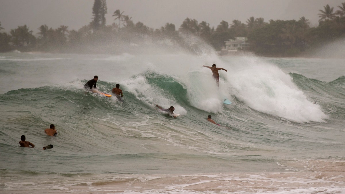 Surfers take on large waves generated by Hurricane Douglas at Laie Beach Park, Sunday, July 26, 2020, in Laie, Hawaii.