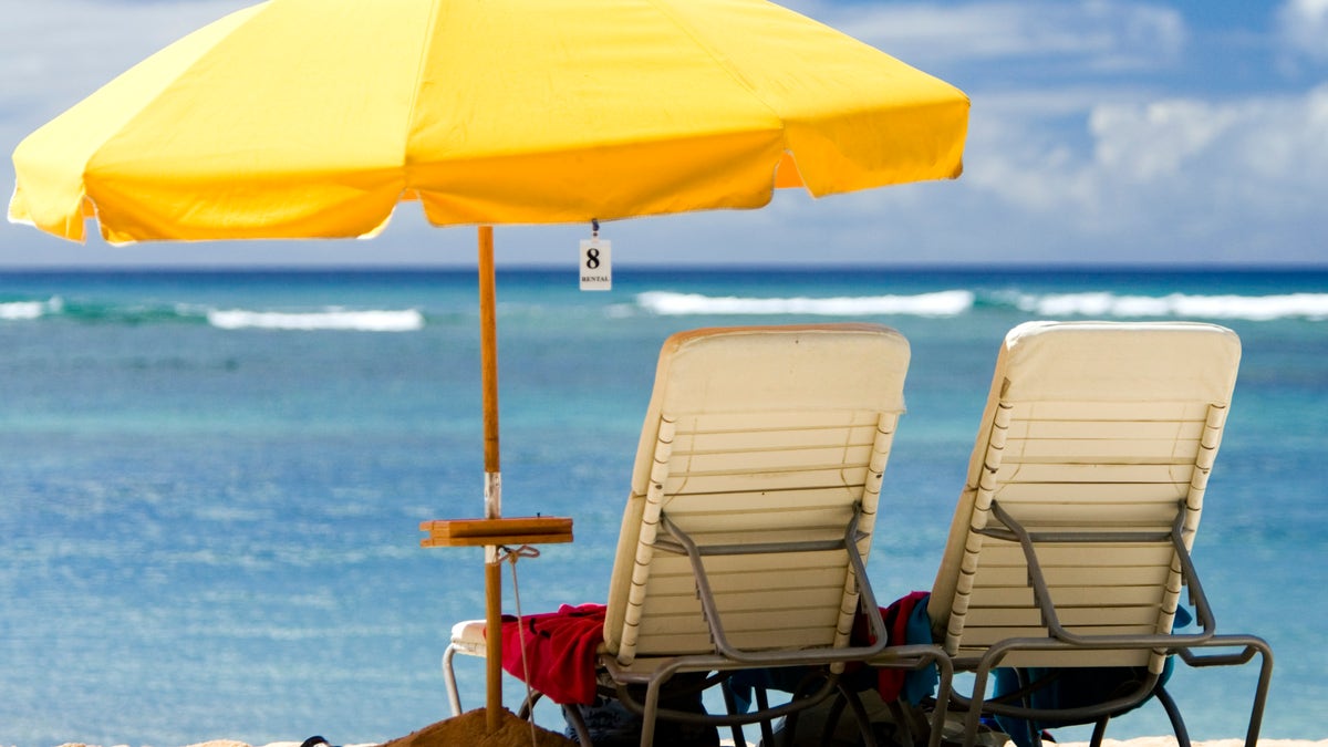 beach chairs under a yellow beach umbrella