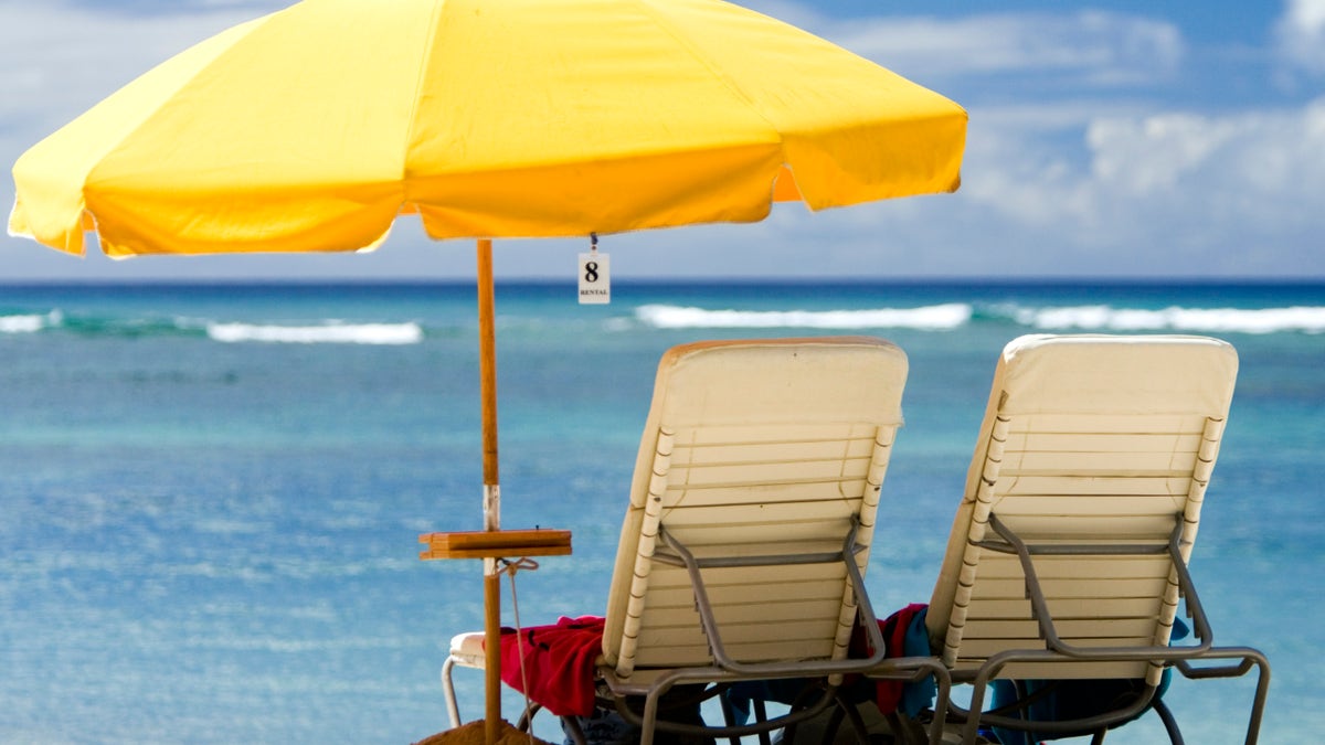 beach chairs under a yellow beach umbrella