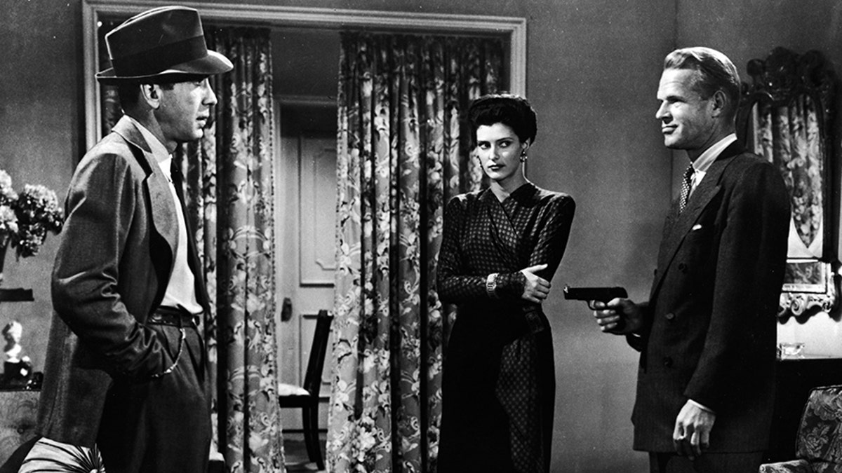 American actors (left - right): Humphrey Bogart, Sonia Darrin, and Louis Jean Heydt (1905 - 1960) in a still from the film, 'The Big Sleep,' directed by Howard Hawks, 1946.