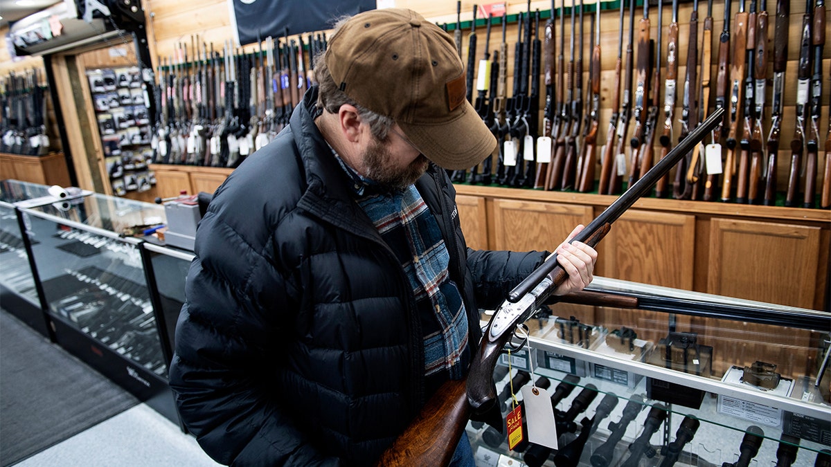 A customer looks at an antique shotgun at Cherry's Outdoor World in Ottawa, Ohio, Jan. 23, 2020. (Photo by BRENDAN SMIALOWSKI/AFP via Getty Images)