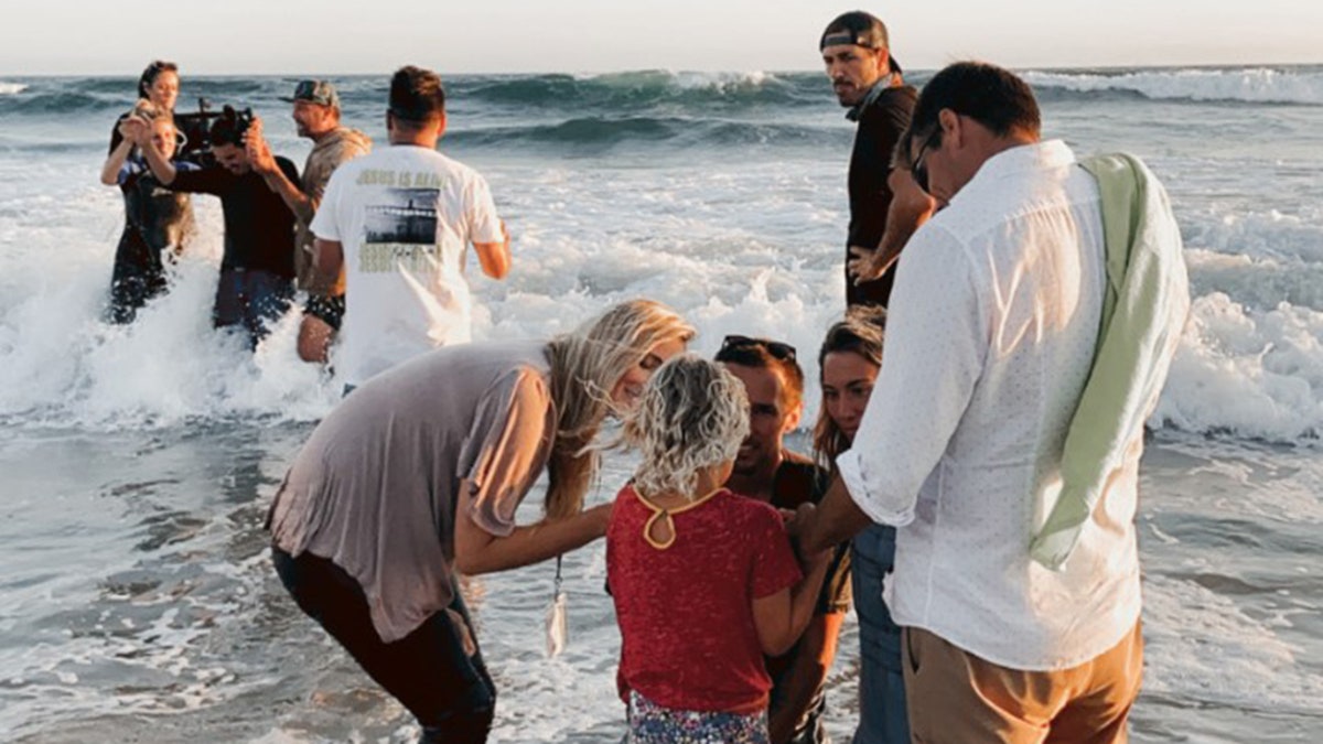 People get baptized at the Saturate OC event July 10, on Huntington Beach, Calif.